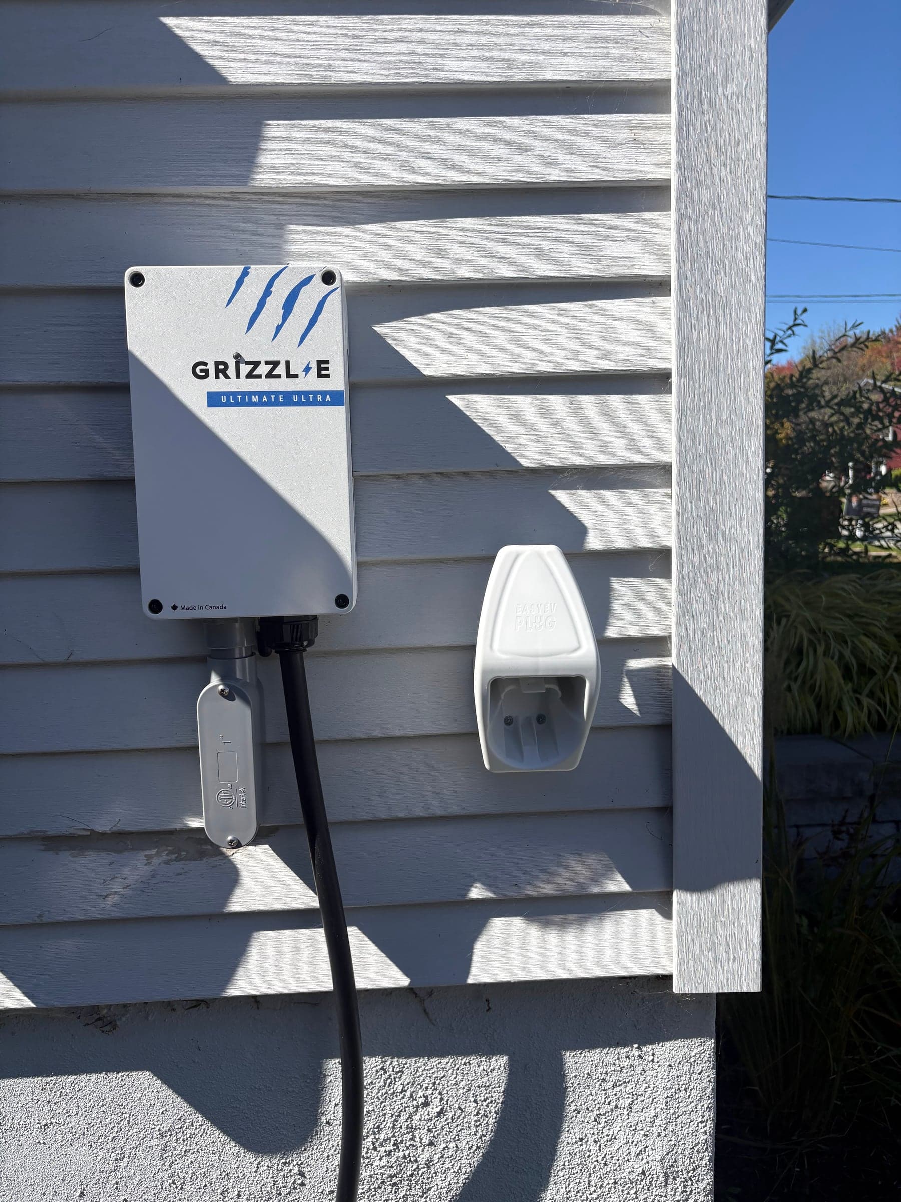 Borne de recharge Grizzl-E de niveau 2 installée sur le revêtement extérieur d’une maison